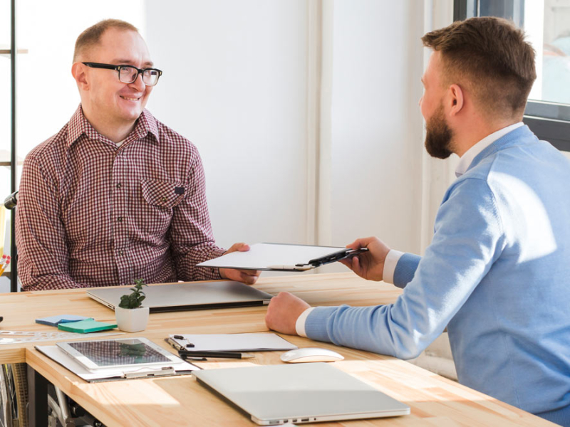 empresaria-explicando-sus-colegas-sobre-computadora-portatil-reunion-junta-lugar-traewfwfebajo